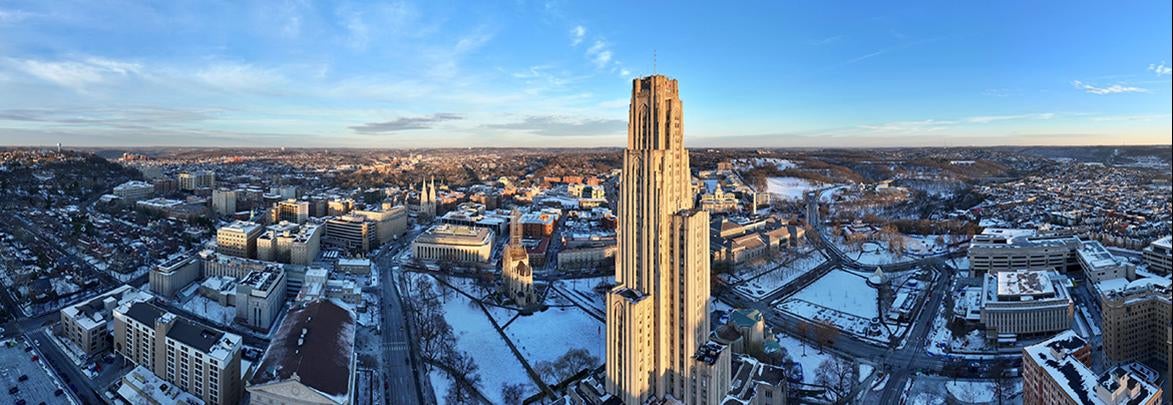 Drone view of Pitt campus in winter with Cathedral of Learning as focal point